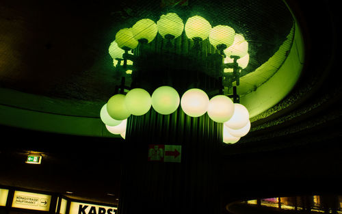 Low angle view of illuminated lighting equipment hanging on ceiling