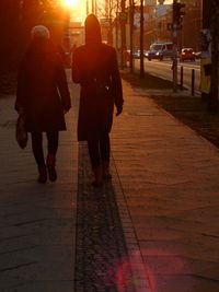 Rear view of people walking on street at night
