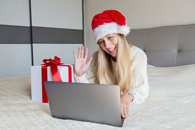 Happy woman celebrating friends with video call. christmas online holiday celebration, new year