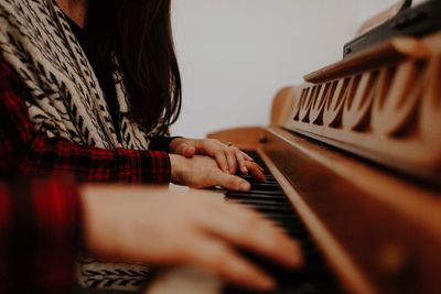 Close-up of woman playing piano at home