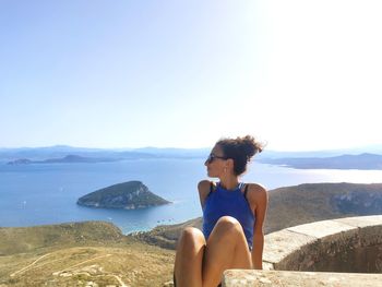 Young woman looking at sea against sky after trekking