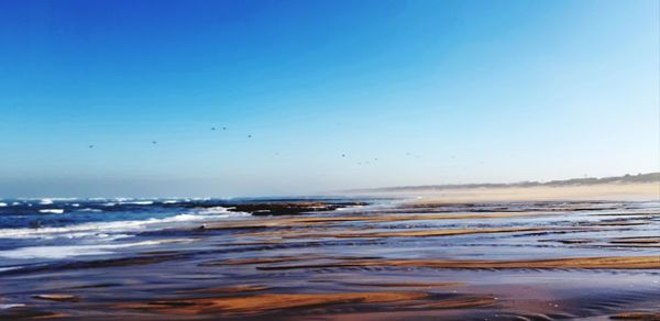 Scenic view of sea against clear blue sky