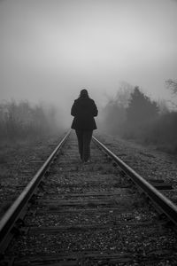 Man standing on railroad track against sky