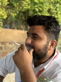 Portrait of young man smoking cigarette outdoors