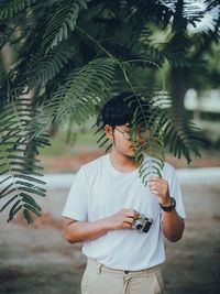 Young man holding plant