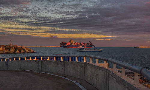 Pier over sea against sky during sunset