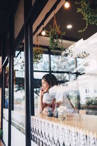 Smiling woman seen through glass at cafe