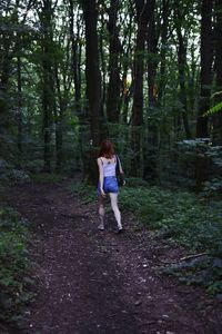 Full length of woman walking through the forest