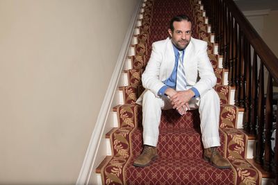 Portrait of smiling mature businessman sitting on staircase