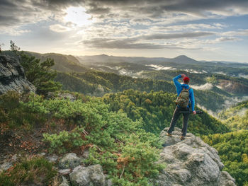 Freelancer createphotos. professional photographer takes photos with camera on tripod on rock