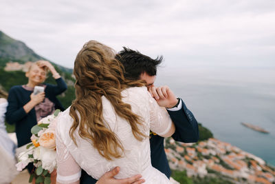 Couple kissing in water against sky