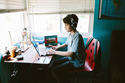 Woman using laptop while sitting on table