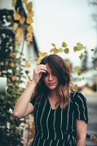 Beautiful young woman standing against blurred background