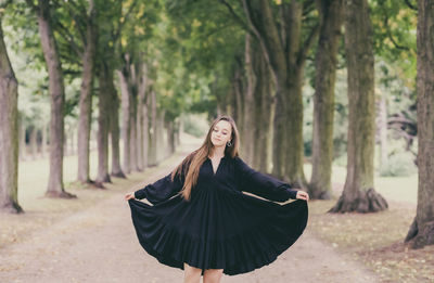 Young woman wearing dress standing in park