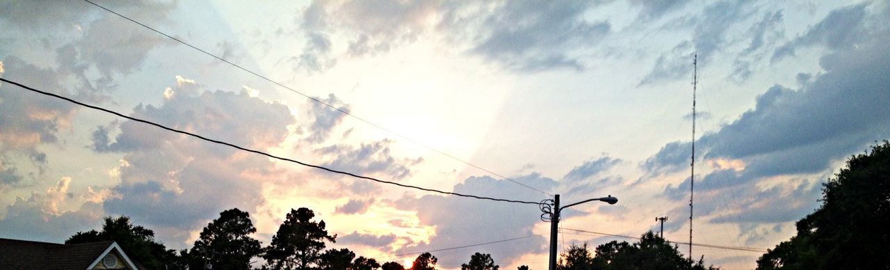 low angle view, sky, silhouette, power line, tree, cloud - sky, electricity pylon, cable, cloudy, cloud, power supply, electricity, nature, sunset, beauty in nature, power cable, street light, sunlight, tranquility, outdoors