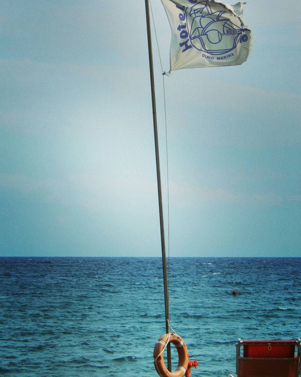 sea, horizon over water, water, transportation, nautical vessel, sky, mode of transport, rippled, boat, tranquility, tranquil scene, nature, part of, scenics, blue, waterfront, beauty in nature, flag, day, copy space