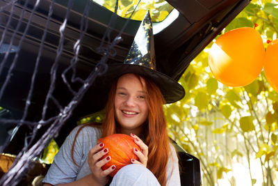 Portrait of smiling young woman holding balloons