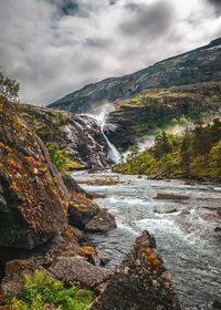 Scenic view of waterfall against sky