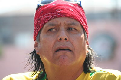 Close-up of mature man wearing red bandana on sunny day