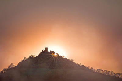 Sun shining on mountain during sunset