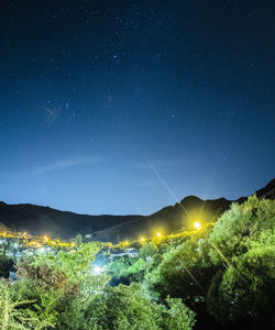 Scenic view of illuminated field against sky at night