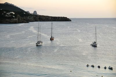 Sailboats in sea against sky