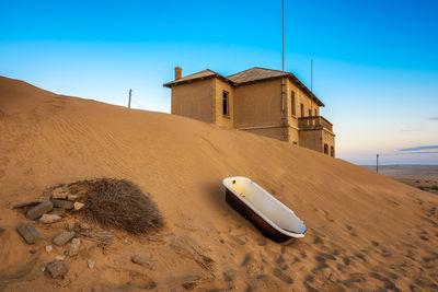 Sand dune on beach against clear sky