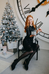 Act of christmas gifts giving. beautiful redhead young woman holding xmas gifts. happy young woman