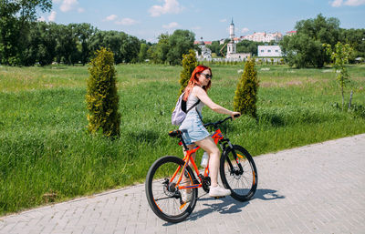 Portrait of woman riding bicycle on field