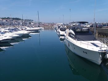 Sailboats moored at harbor