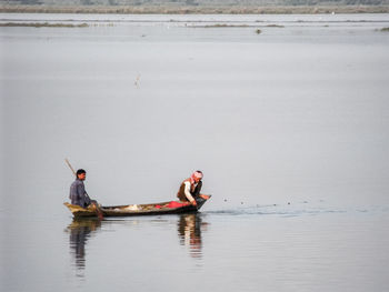 Men sitting in fishing boat on lake