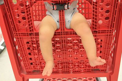 Low section of baby sitting in shopping cart