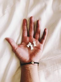 High angle view of woman hand on bed