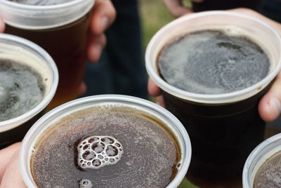 Close-up of hand holding black coffee in market