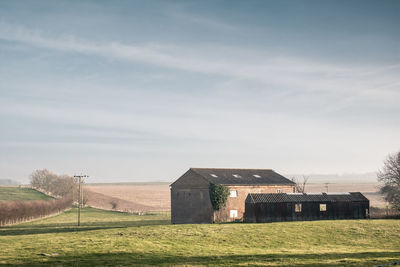 Barn on field against sky