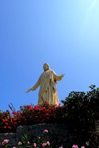 Low angle view of statue against blue sky