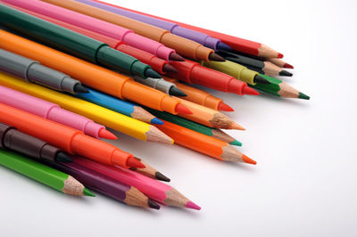 High angle view of colored pencils against white background