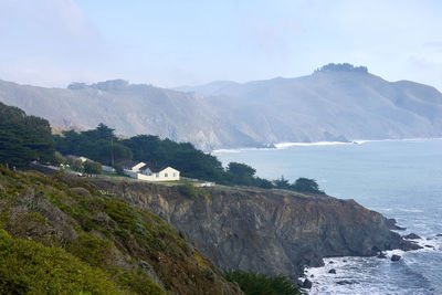 Scenic view of sea and mountains against sky
