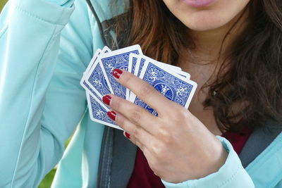 Midsection of woman holding cards