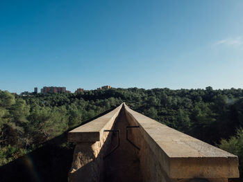 House amidst trees and buildings against clear blue sky