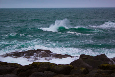 Scenic view of rocks in sea against sky