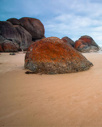 Rock formation on beach against sky