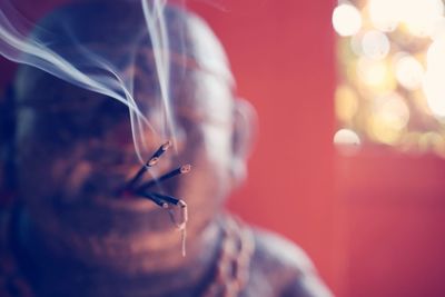 Close-up of statue with burning incense in temple