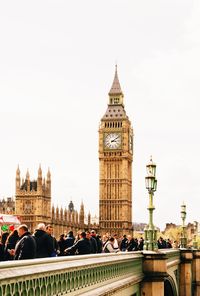 People on bridge against big ben