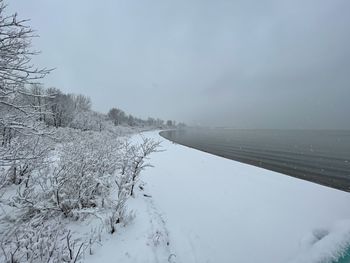 Scenic view of snow covered land against sky