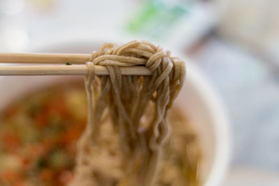 Close-up of eating soba noodles with cjopsticks