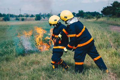 Firefighters by fire on field