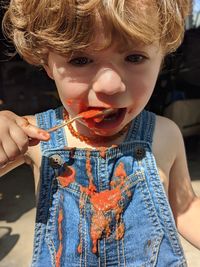 Portrait of a boy eating tomato sauce