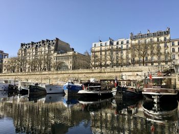 Réflection of sailboats in seine river with buildings in background in paris 