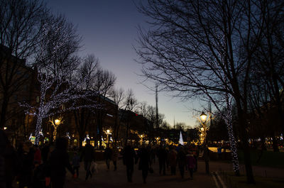 People walking in illuminated city at night